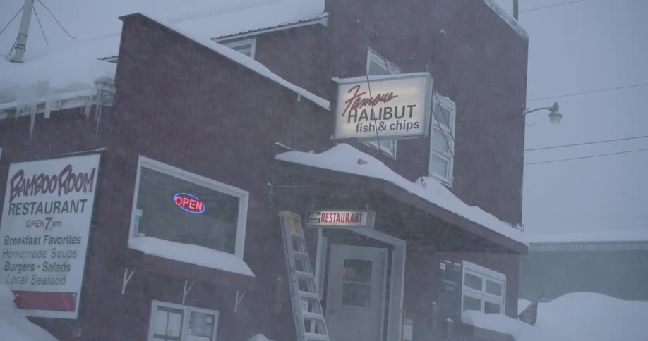 Snow and ice coat the exterior of a small town restaurant during a winter storm