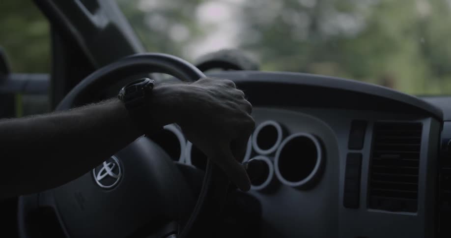 A man drives down a tree lined road