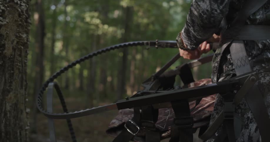 A hunter adjusts his gear in the woods