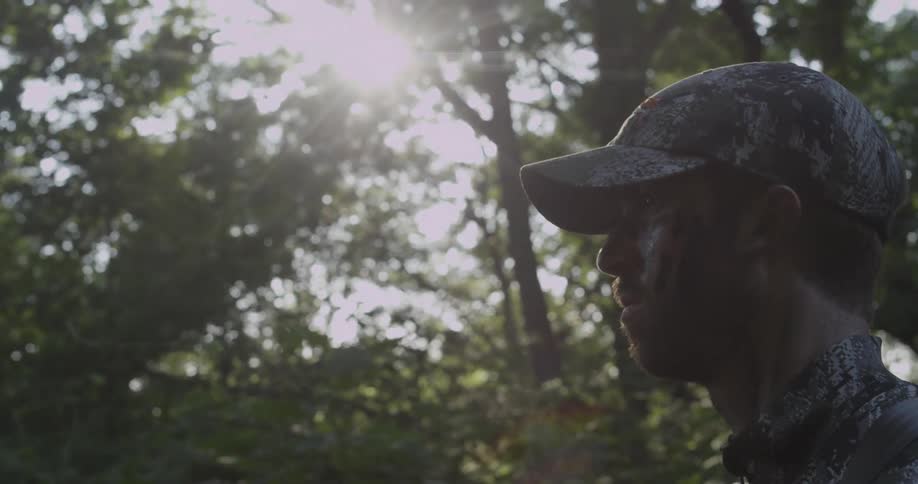 A man looks into the woods ahead
