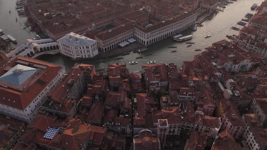 Aerial view of an urban canal with historic buildings and moving boats
