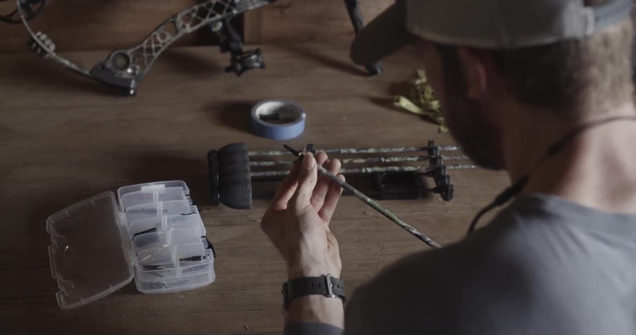 A man glues an arrow and puts it in a quiver