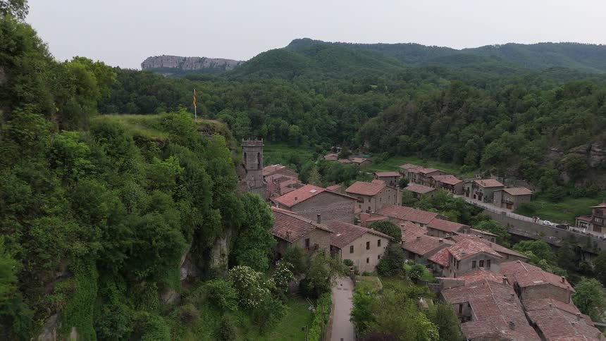 Tower overlooking buildings close together in a forested mountain valley community