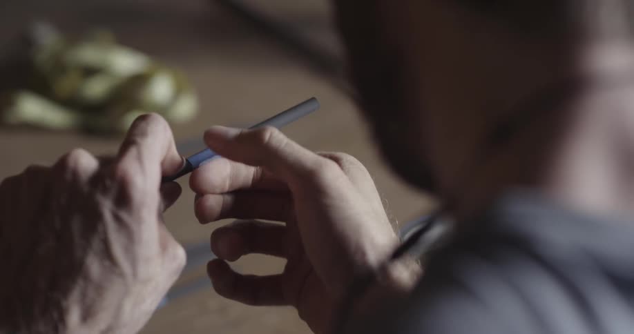 A man wraps tape onto a rod