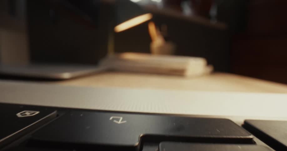 Finger pressing keys on a laptop keyboard during typing