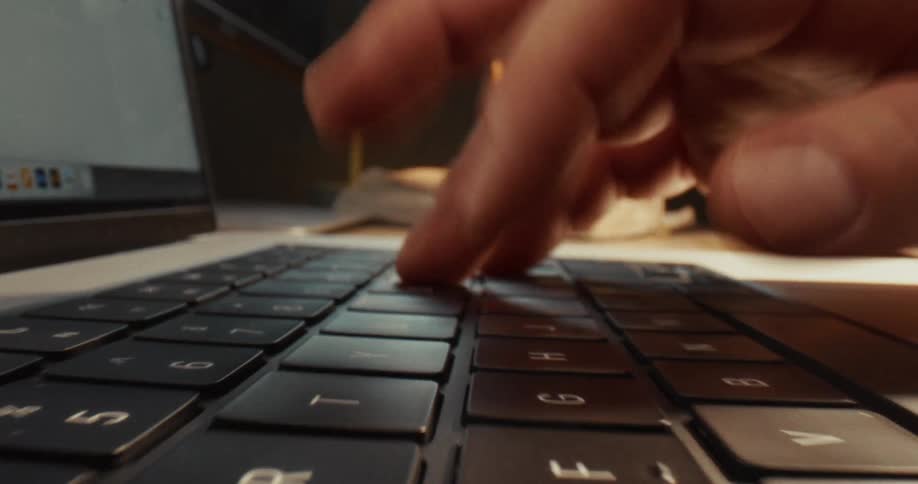 A person is typing on a laptop keyboard