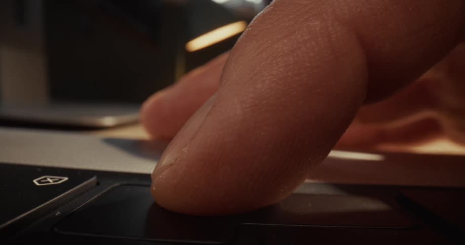 Closeup of a hand typing on a laptop keyboard in a modern workspace