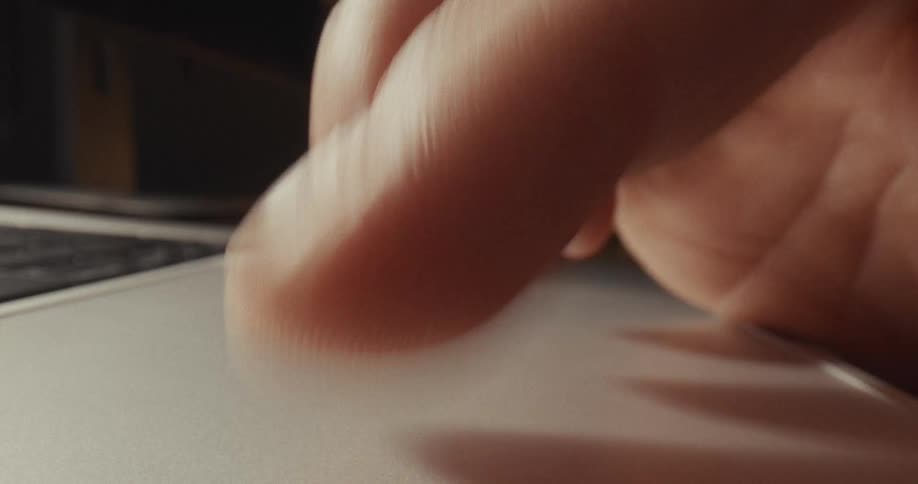 Fingers tap and move across a laptop trackpad