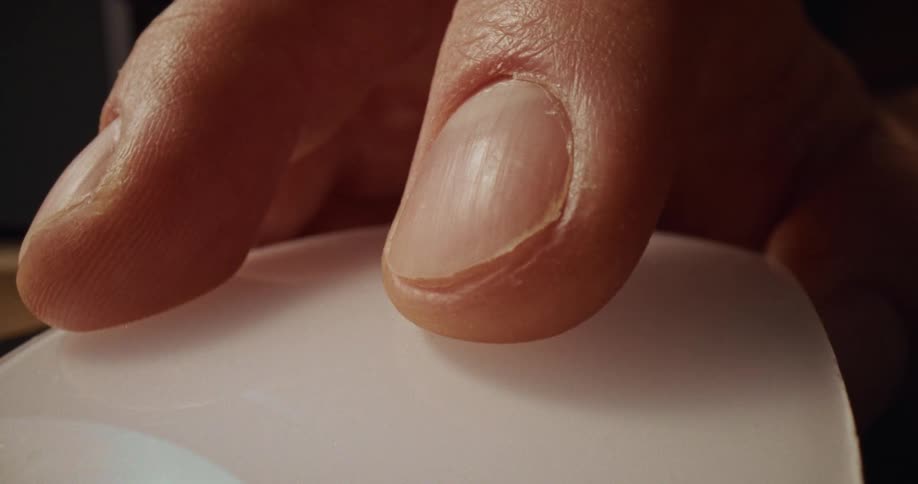 Adult male human hand clicking on a mouse over a desk next to a window indoors