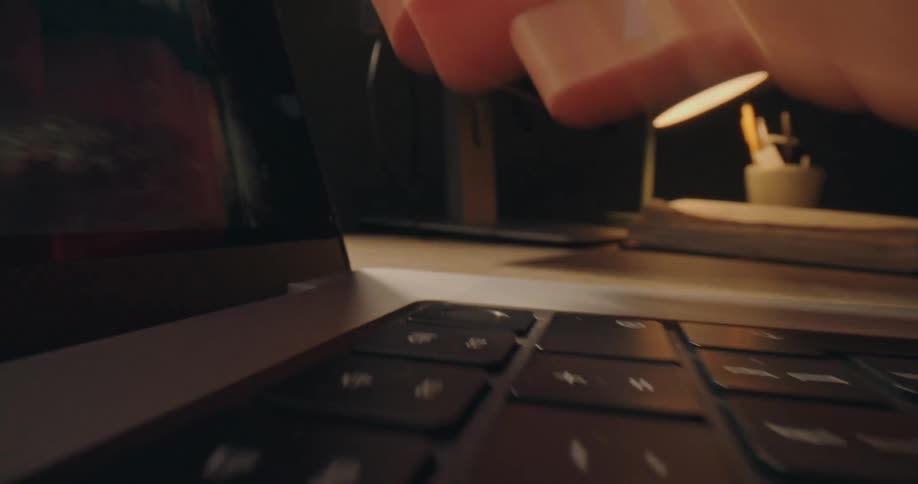Finger pressing a laptop keyboard key near the screen