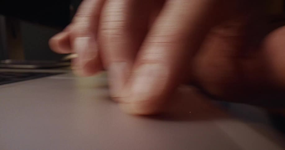 A finger rapidly scrolls across a laptop trackpad