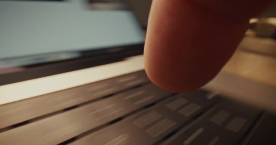 A finger types on a keyboard