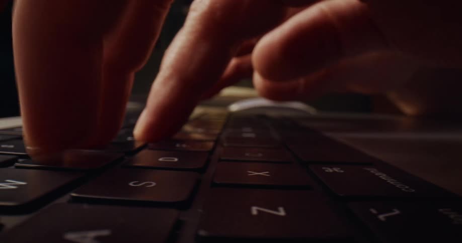 Fingers typing on the keyboard of a laptop computer
