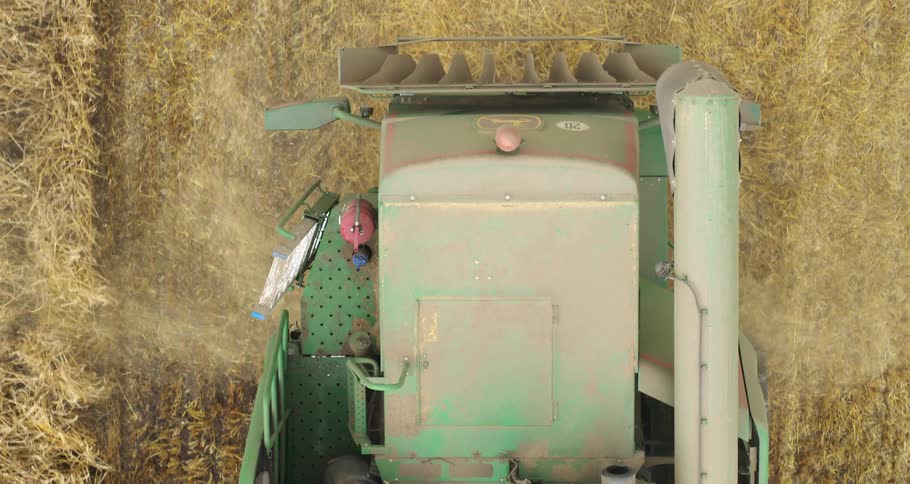Harvester moves across a crop field harvesting during the daytime
