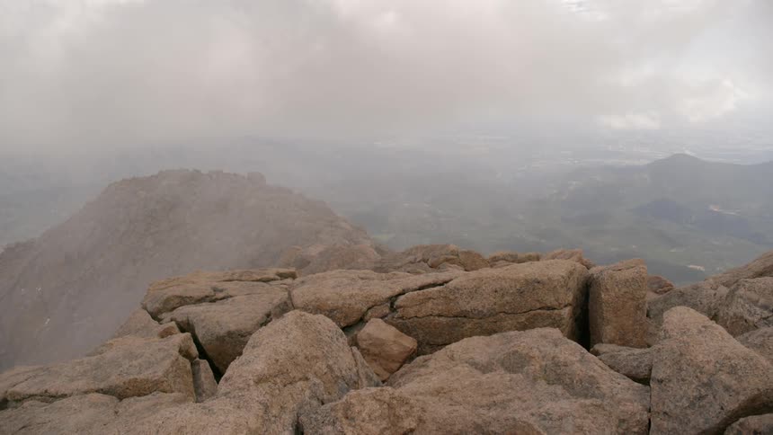 Clouds and mist move over a rocky mountain ridge line