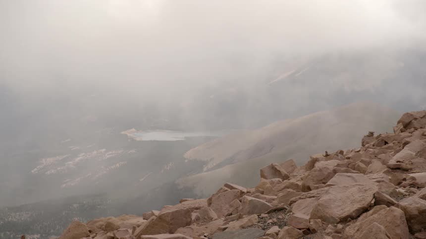 Fog drifts over a rocky slope
