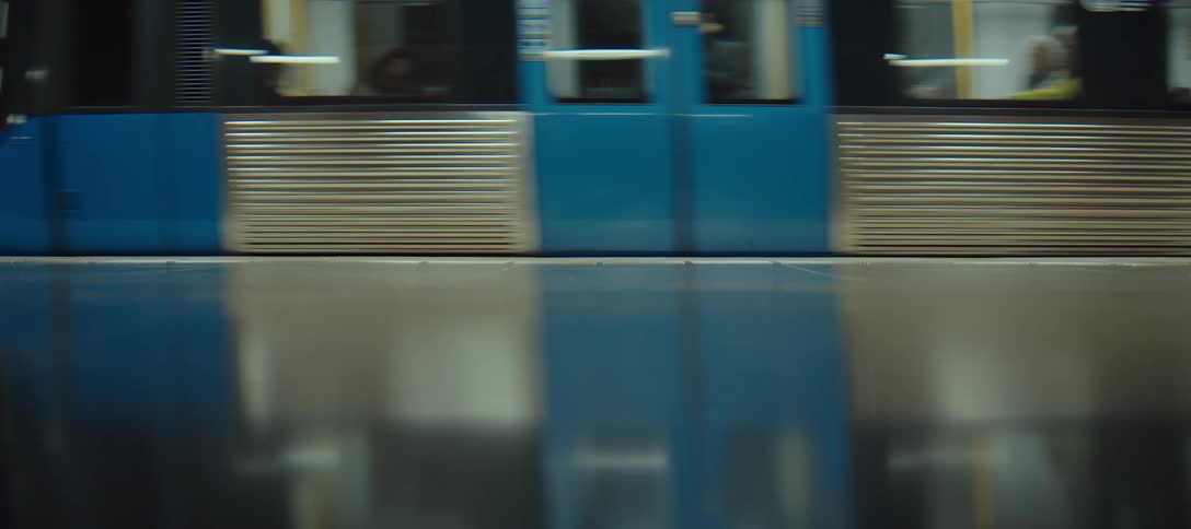 Blue train in motion passing the platform with reflection on the polished floor