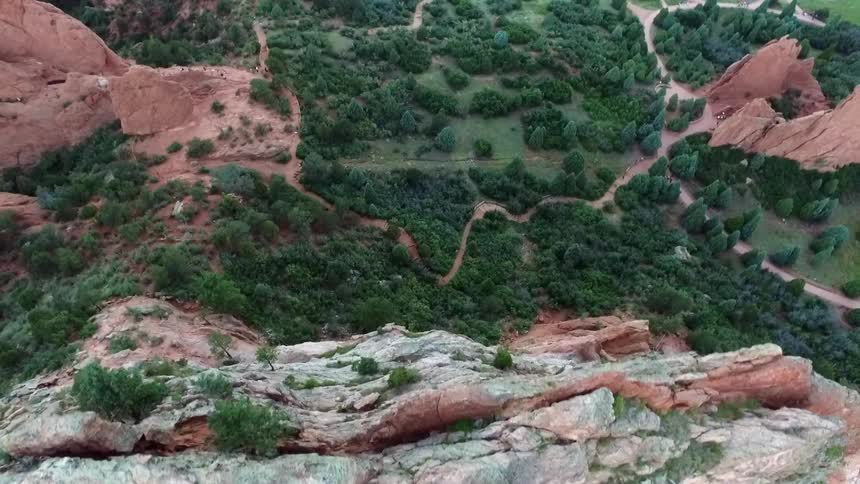 A tall, narrow rock surrounded by trees