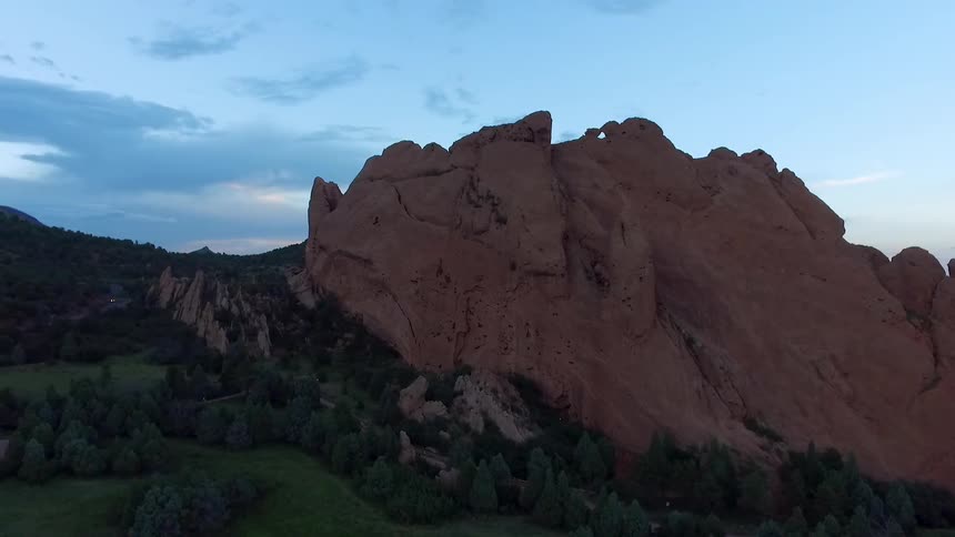 Trees line the foot of a cliffside