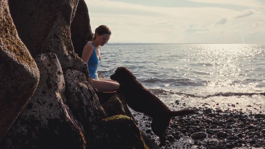 A woman and her dog at the beach
