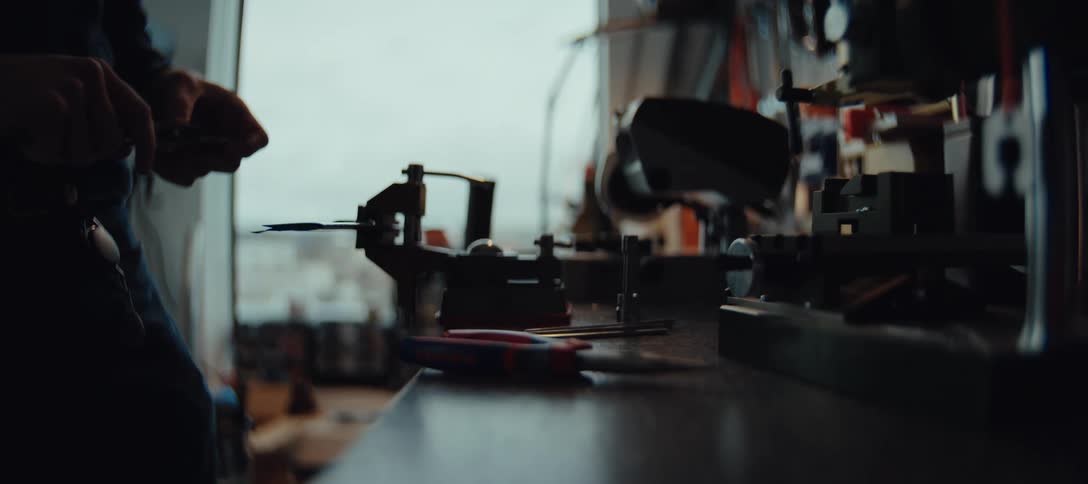 Hands adjust caliper over workbench with precision tools