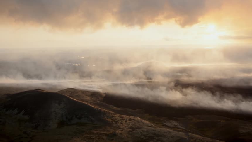 Mountain valley covered by mist under early morning light