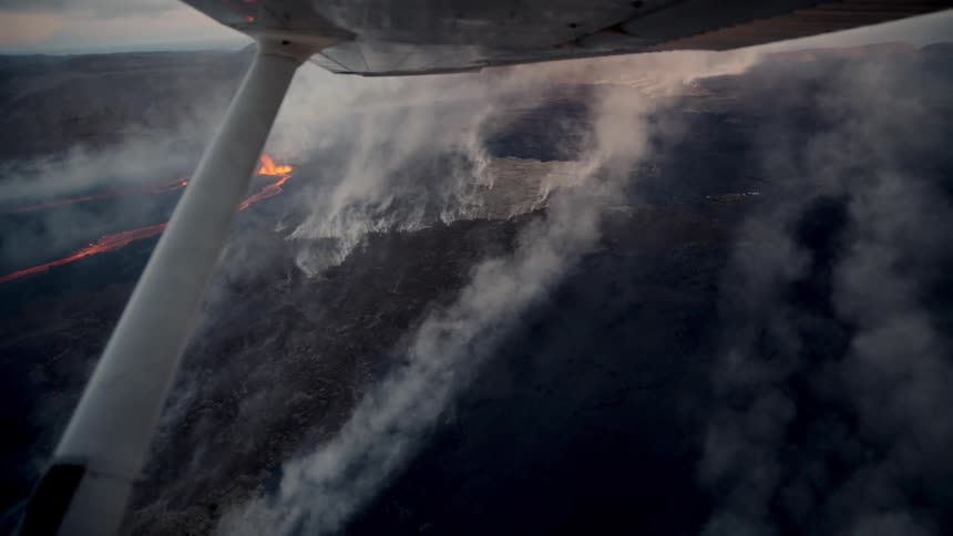 Volcanic activity and surrounding landscape seen from an airplane in flight outdoors