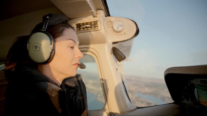 A woman flying a plane outdoors