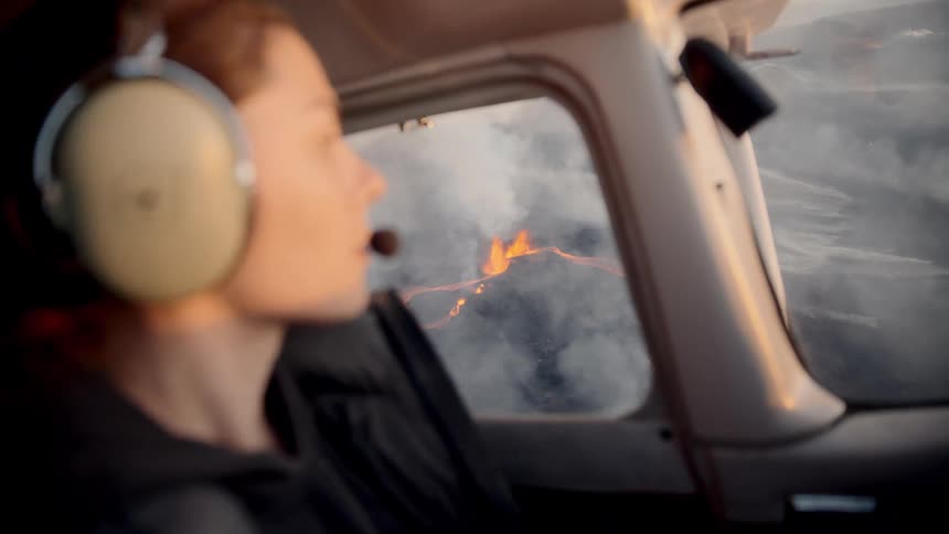 Woman piloting a plane and observing volcanic activity