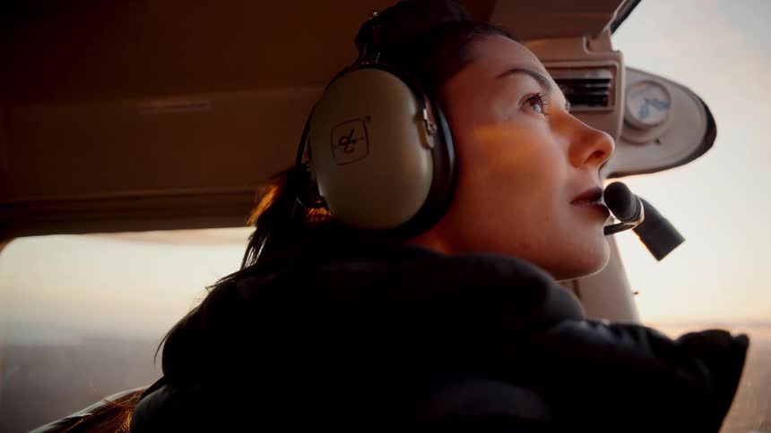 A woman flying a plane on a sunny day