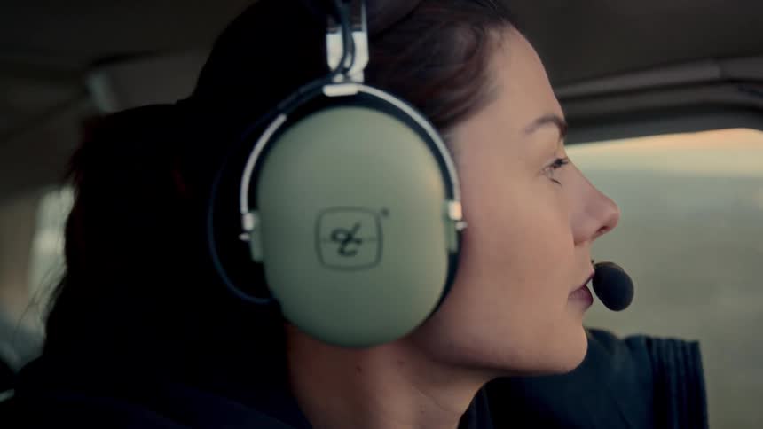 Woman wearing headphones on a flight