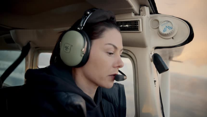 A woman flying a plane on a cloudy day