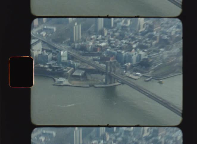 Aerial view of a bridge crossing a river surrounded by dense urban area