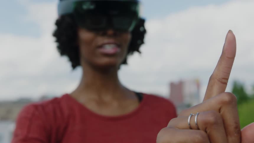A woman waves her finger in front of her vr headset