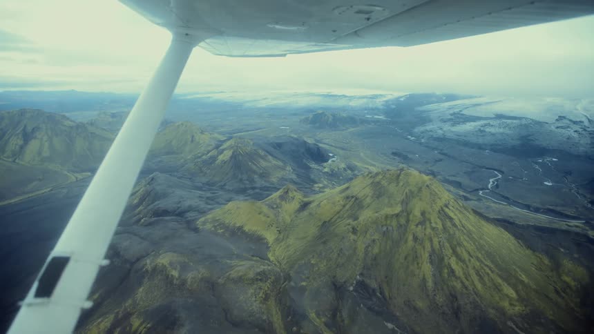 Mountains across the landscape seen from under a small airplane