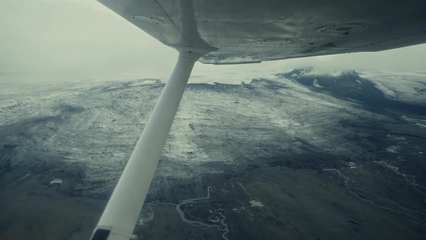 The plane is flying over the frozen area