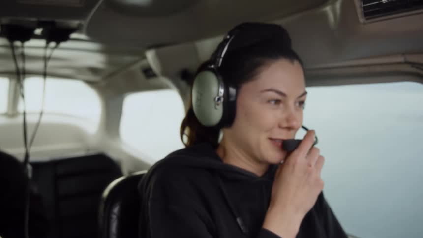 Woman with headphones communicating midflight