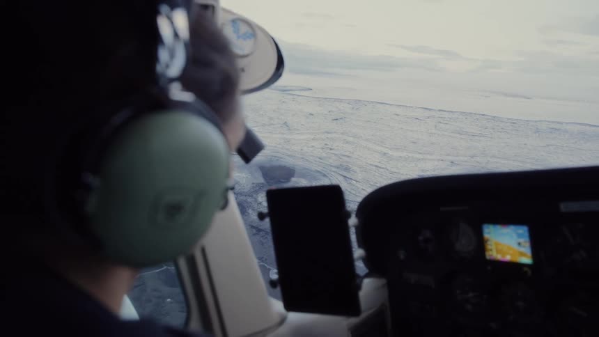 Woman with headphones focused piloting a plane
