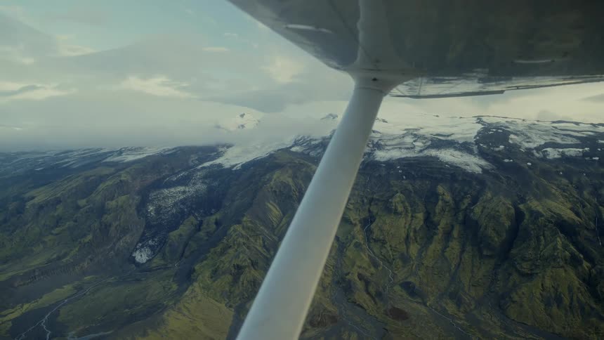 Aerial panorama of verdant mountains with snowcapped peaks