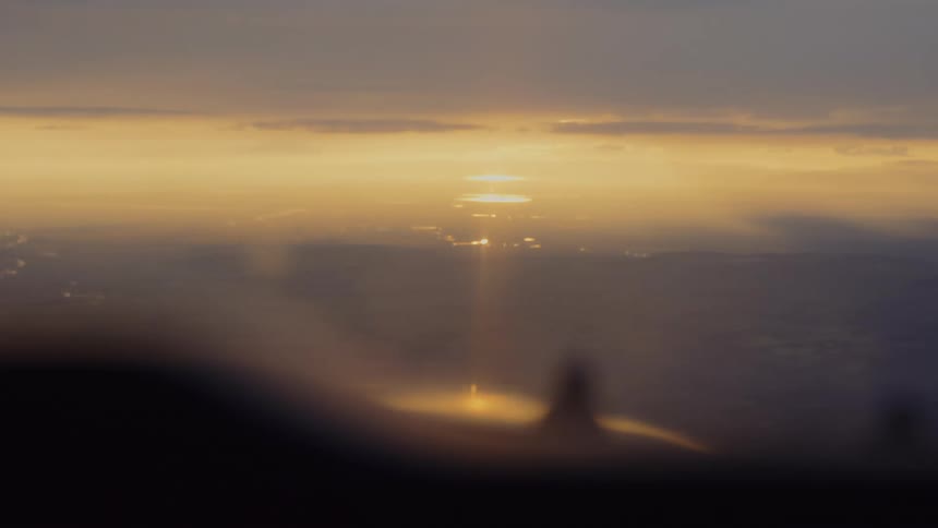 Aircraft flies over a foggy landscape during the daytime