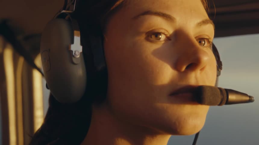 A woman flying a plane with a headset on