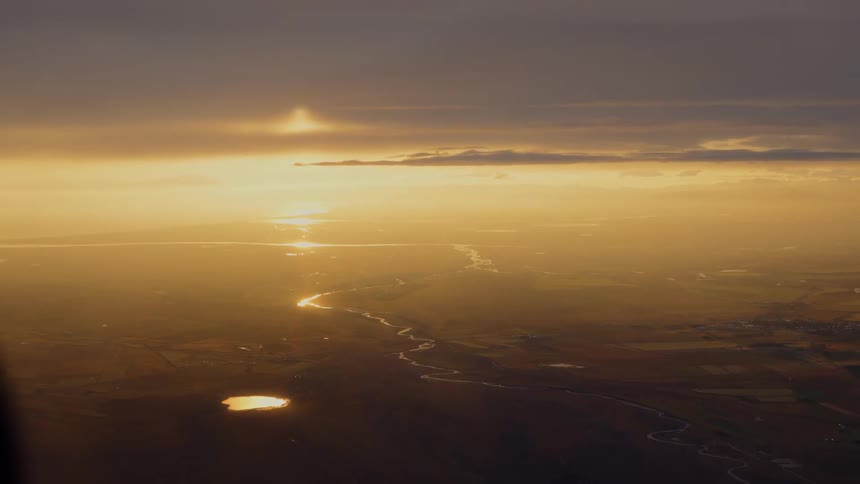 Aerial panorama of the golden sun on the horizon illuminating natural areas