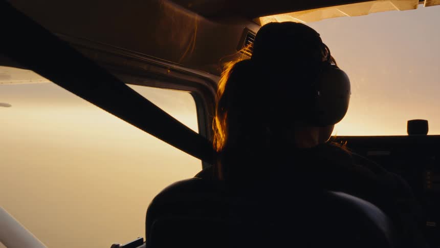 A woman flying a small plane on a sunny day