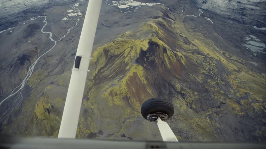 Landing gear of an airplane suspended in midair during flight over mountains