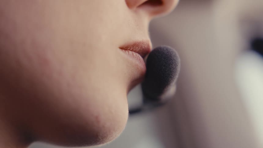 A persons mouth positioned near a headset microphone