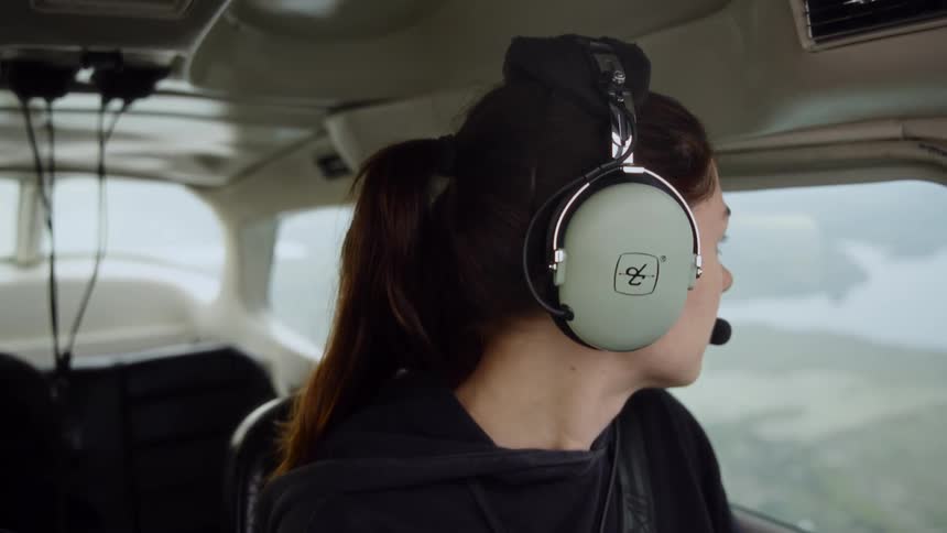 Woman piloting a small plane and observing the surrounding landscape