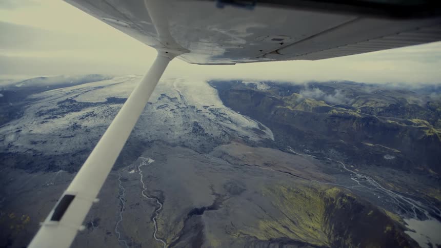 A view of mountains and rolling hills as seen from an aircraft at midday the landscape stretching out beneath the bright even light