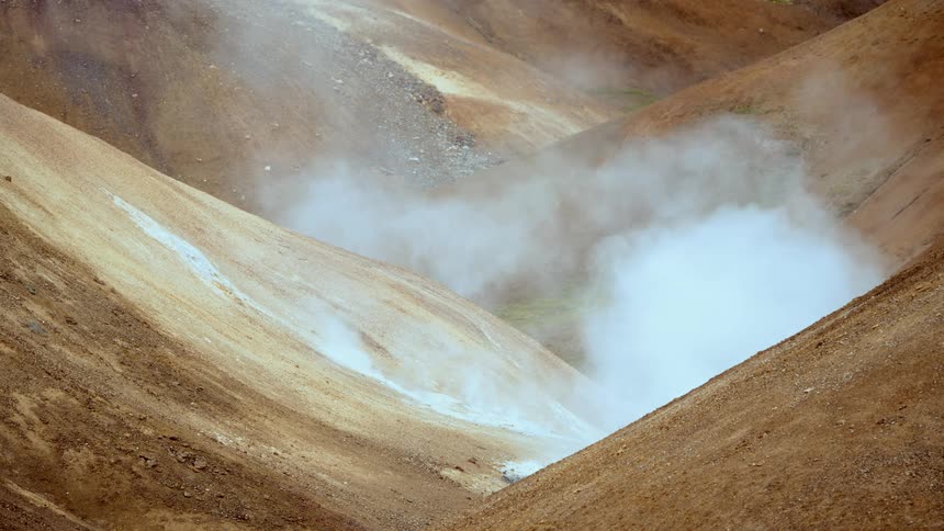Landscape of volcanic mountains emitting smoke