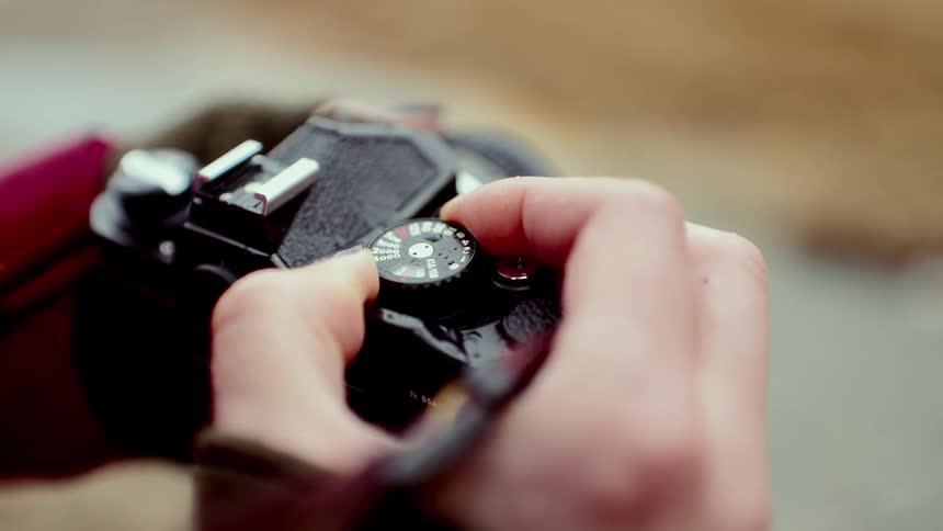 Womans fingers turning a dial on her camera