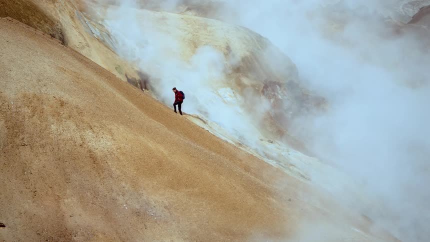 The hiker is climbing up the mountain